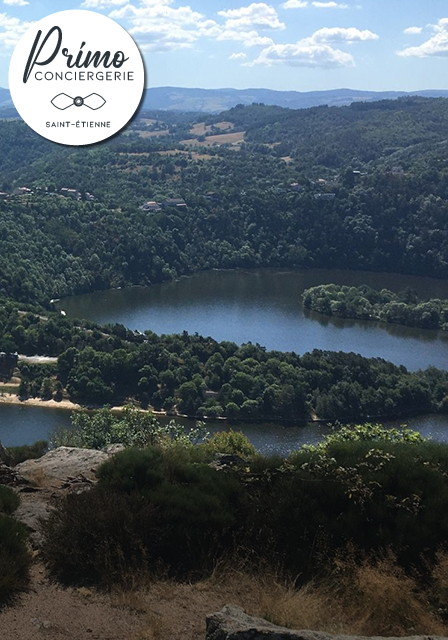 Vue panoramique de collines boisées et d'un lac près de Saint-Étienne.