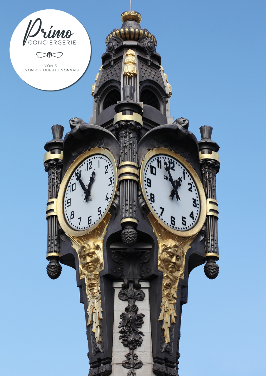 Horloge historique de Lyon avec des détails dorés et des sculptures sur fond bleu clair.